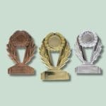 Guld, sølv, bronze trofæer på grøn baggrund