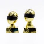 Guldrobotfigurer på piedestaler med sorte visirer.