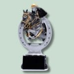 Ridetrofæ med hestesko og rytter i spring.