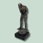 Miniature golfspiller statue på sort sokkel.