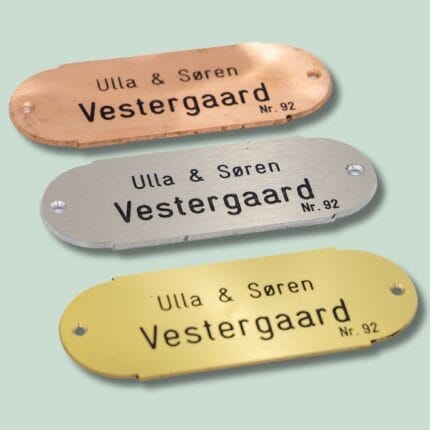 Tre navneskilte i forskellige metaller.