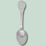 Sølv teske med indgraveret mønster på håndtaget.