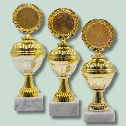 Tre gyldne trofæer på marmorbase
