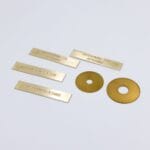 Messingplader med indgraveret tekst og huller