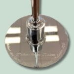 Sølvplade med gravering af navn og dato.