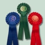 Tre præmie rosetter i blå, grøn og rød.