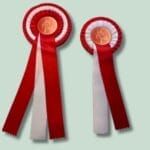 Rød og hvid præmie roset med heste motiv.