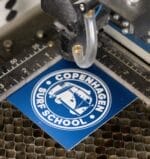 Copenhagen Surf School logo under laser cutter.