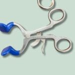 Saks af metal med blå håndtag på grøn baggrund.