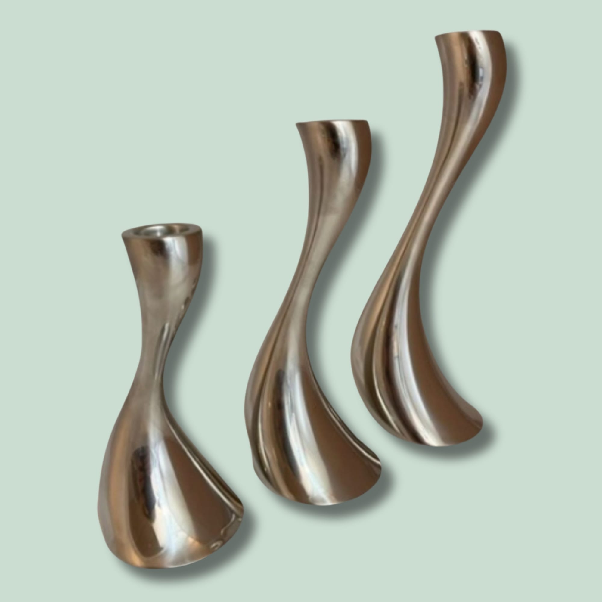 GJ - COBRA Tre skulpturelle metalstager på grøn baggrund.