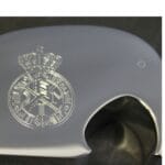 Gravéring på blank overflade med inskription og krone.