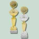 To pokaler, gylden og sølv, på marmorsokkel.